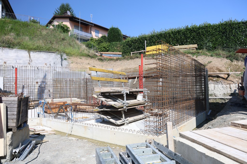 [Two-lane construction site for embankment of an elevated road, two concrete blockwork retaining walls. Steel grid, formwo...